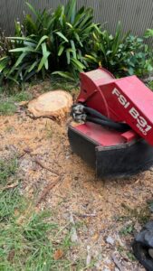 Stump grinder in action removing a tree stump from the ground.